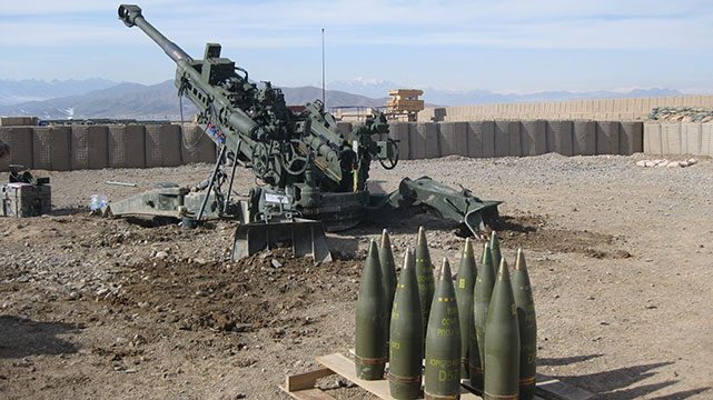 American M777 towed Howitzer with 155mm high explosive artillery shell on the desert